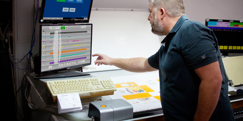 Operator reviewing press‑side color data in MeasureColor Production software as part of closed-loop automation and closed-loop color control for offset printing.